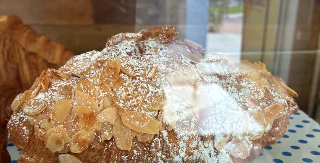 A dusted almond croissant in the cafe cabinet