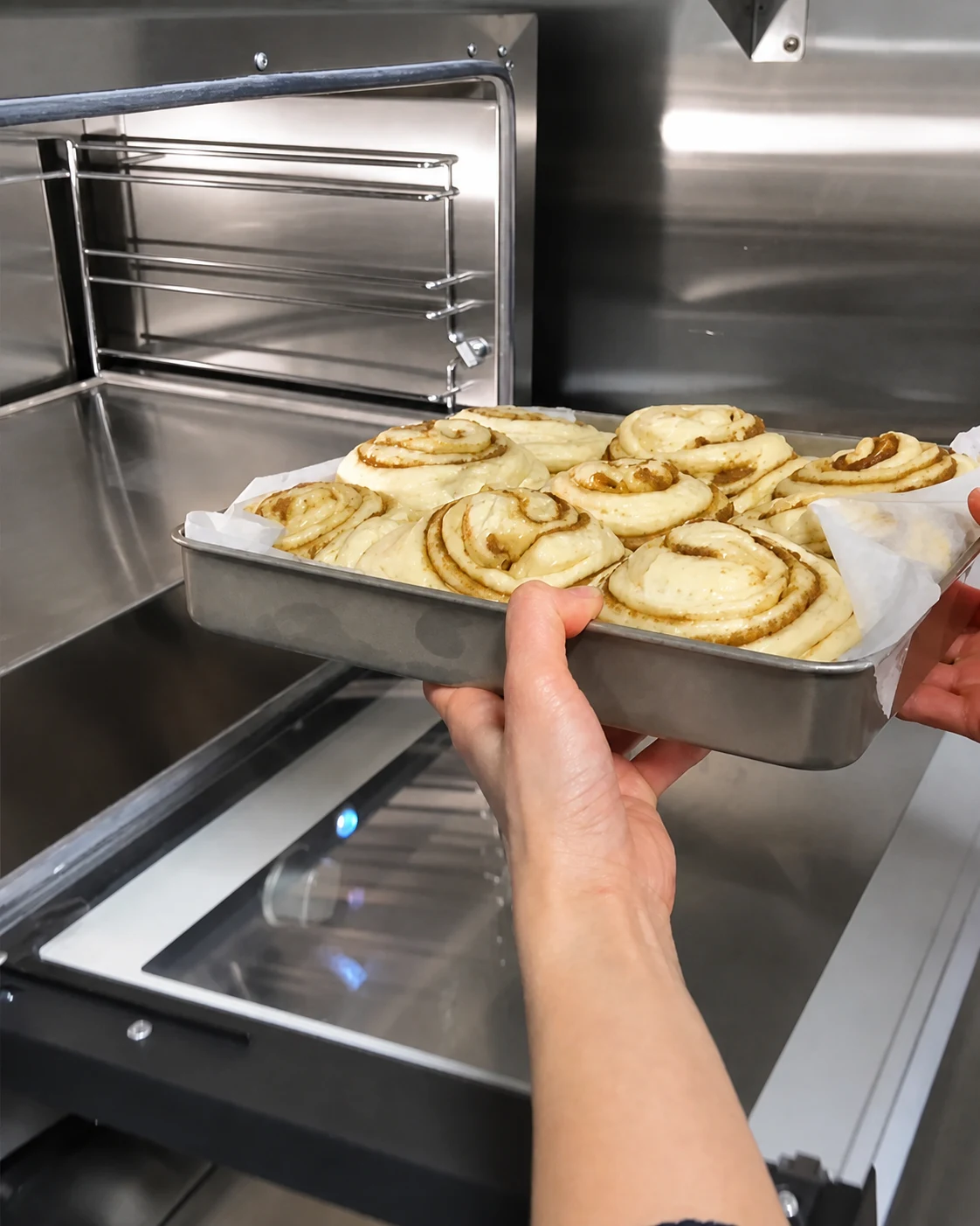 A tray of cinnamon scrolls going into the oven