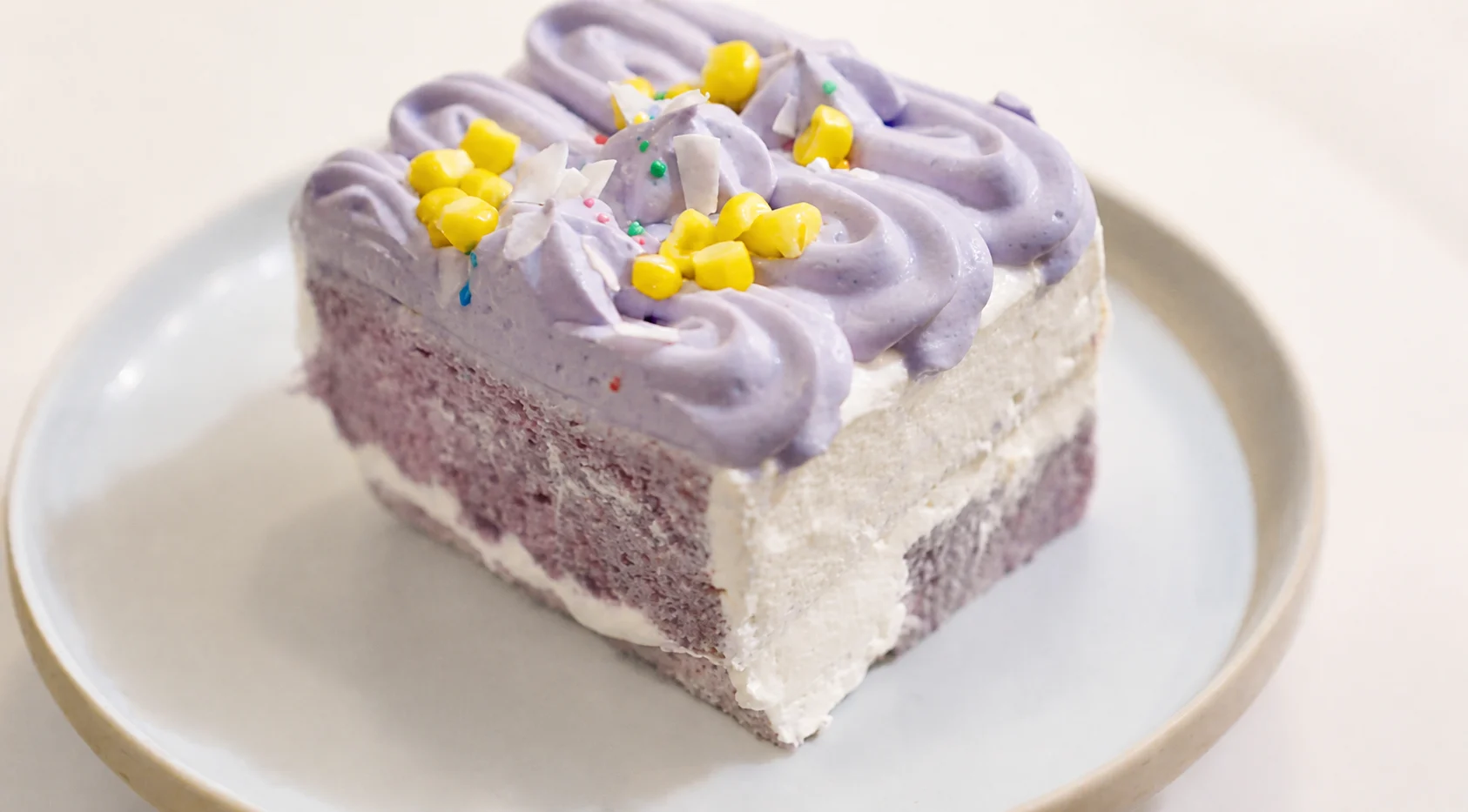 Purple and vanilla layered cake with piped frosting