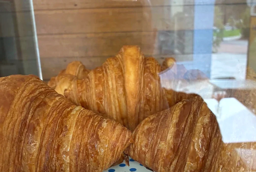 Fresh plain croissants in the pastry cabinet