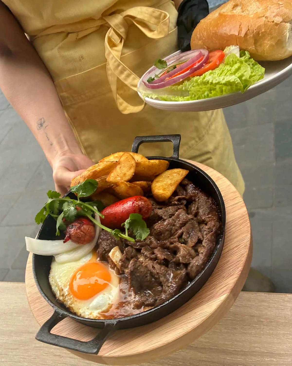A Linnie Cafe team member serving the signature sizzling steak
