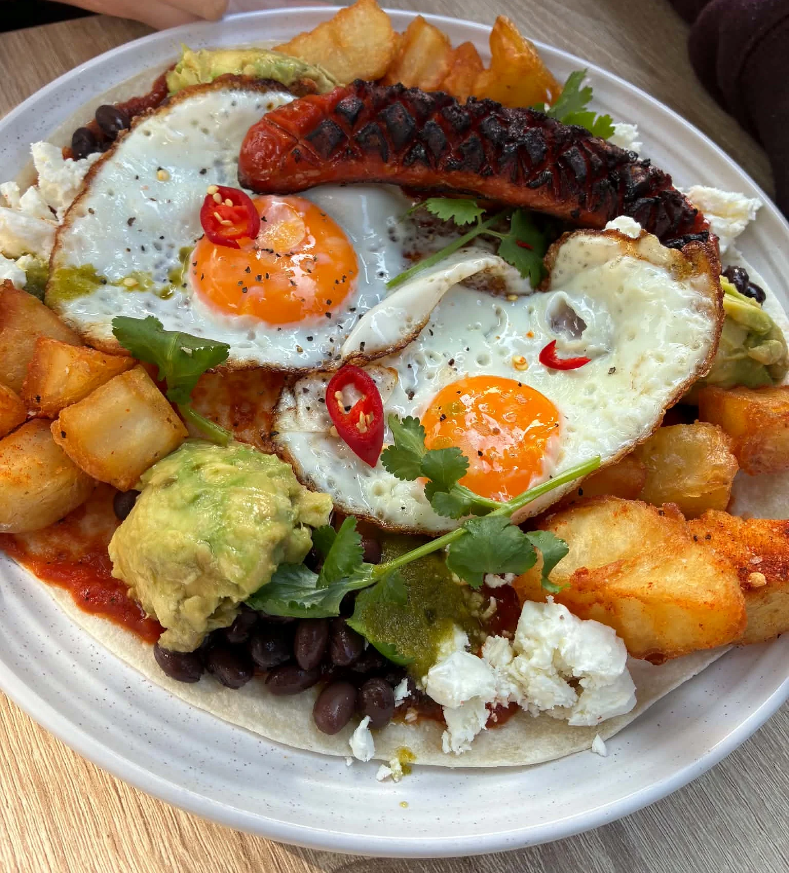 Mexican-style breakfast with eggs, chorizo, avocado, beans and crisp potatoes